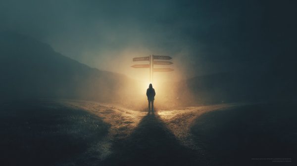 Una persona en una encrucijada con una luz guía.