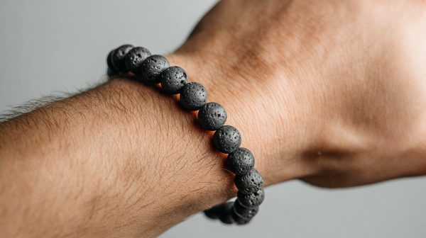 Pulsera difusora de piedra de lava en una muñeca, con un sutil brillo de aceite esencial.