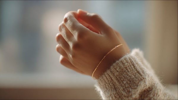 Hand gently holding a simple bracelet, symbolizing calm and intention.