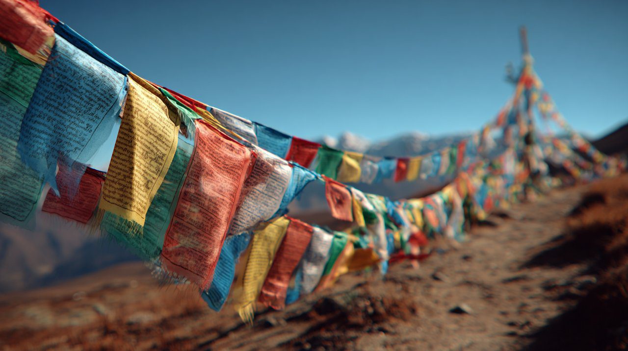 Vibrant Sanskrit prayer flags fluttering on a mountain pass.